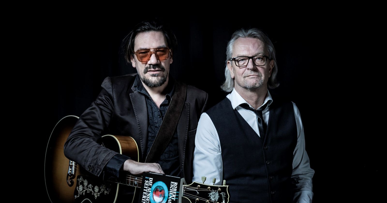 Robert Eichenauer und Christian Stani mit Gitarren, Porträt zum literarisch-musikalischen Abend Die Nacht der Außenseiter in der Thalia Wien.