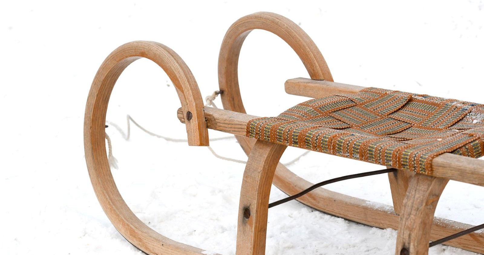 Eine Rodel aus Holz steht im Schnee