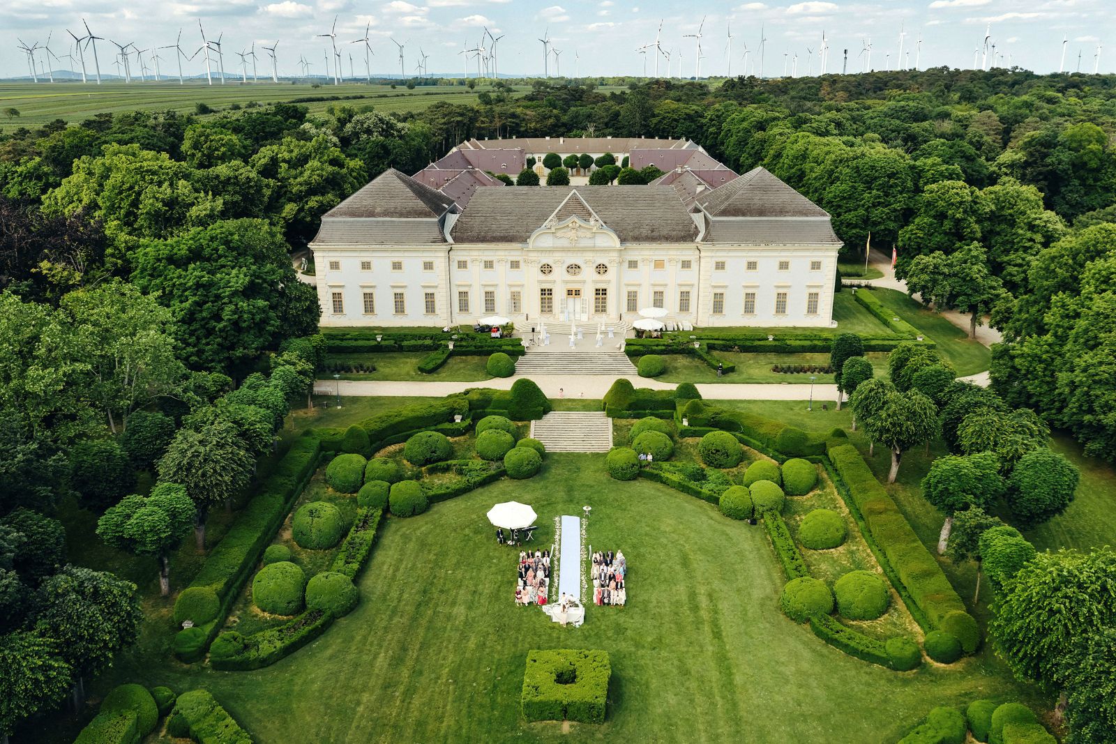 Luftaufnahme von Schloss Halbturn im Burgenland mit barocker Fassade, symmetrischer Gartenanlage und weitläufigem Park.