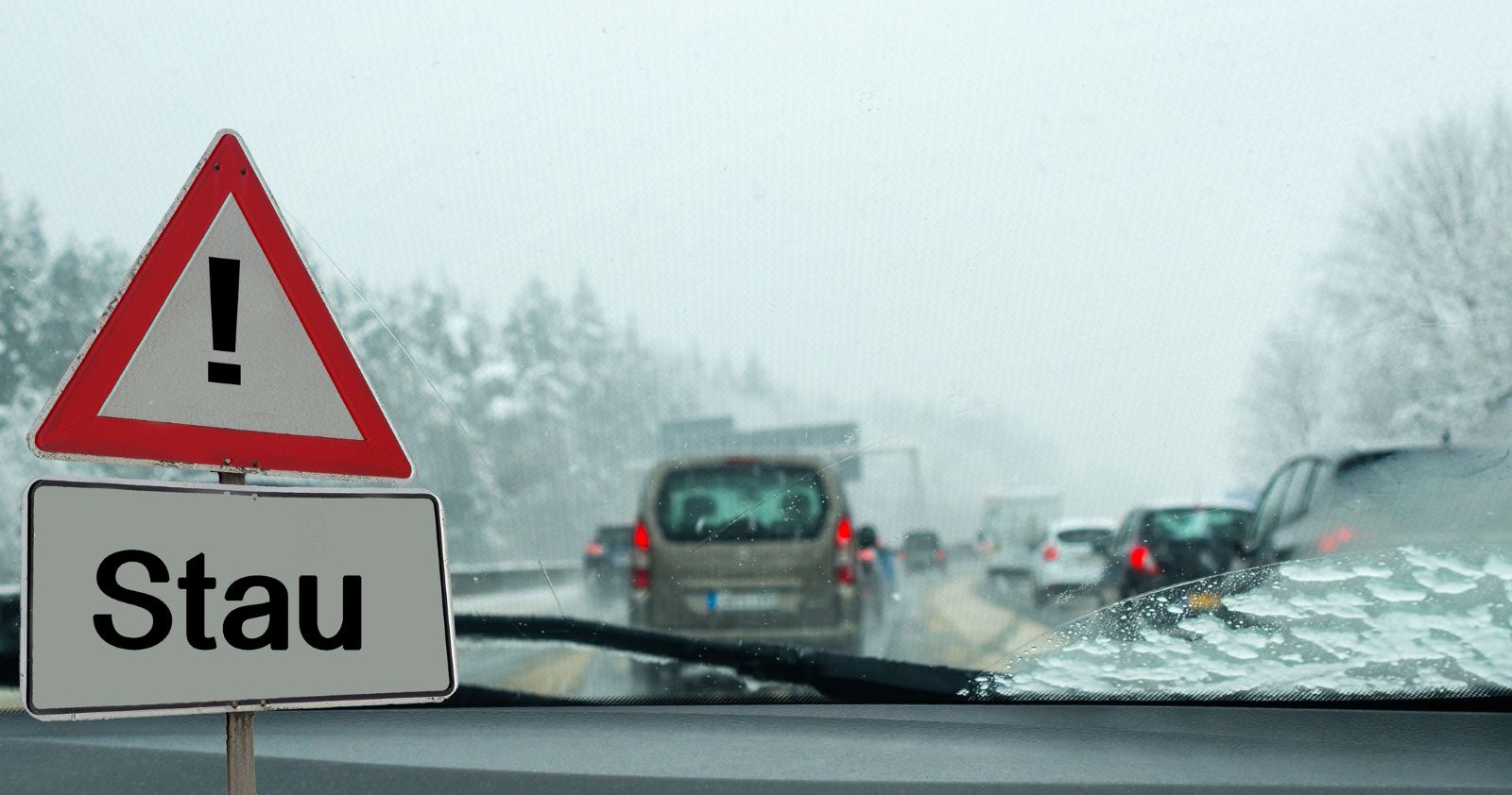 Autos stehen im Stau auf einer verschneiten Autobahn in Österreich, während Schneefall und schlechte Sicht den Verkehr behindern.