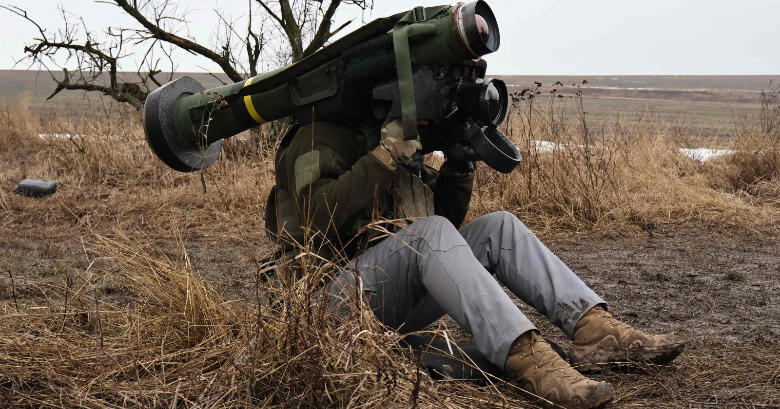 Ukrainischer Soldat mit Javelin-Panzerabwehrwaffe sitzt im Feld und bereitet den Abschuss vor – Themenbild für die Rückereroberung von Gebieten durch die Ukraine