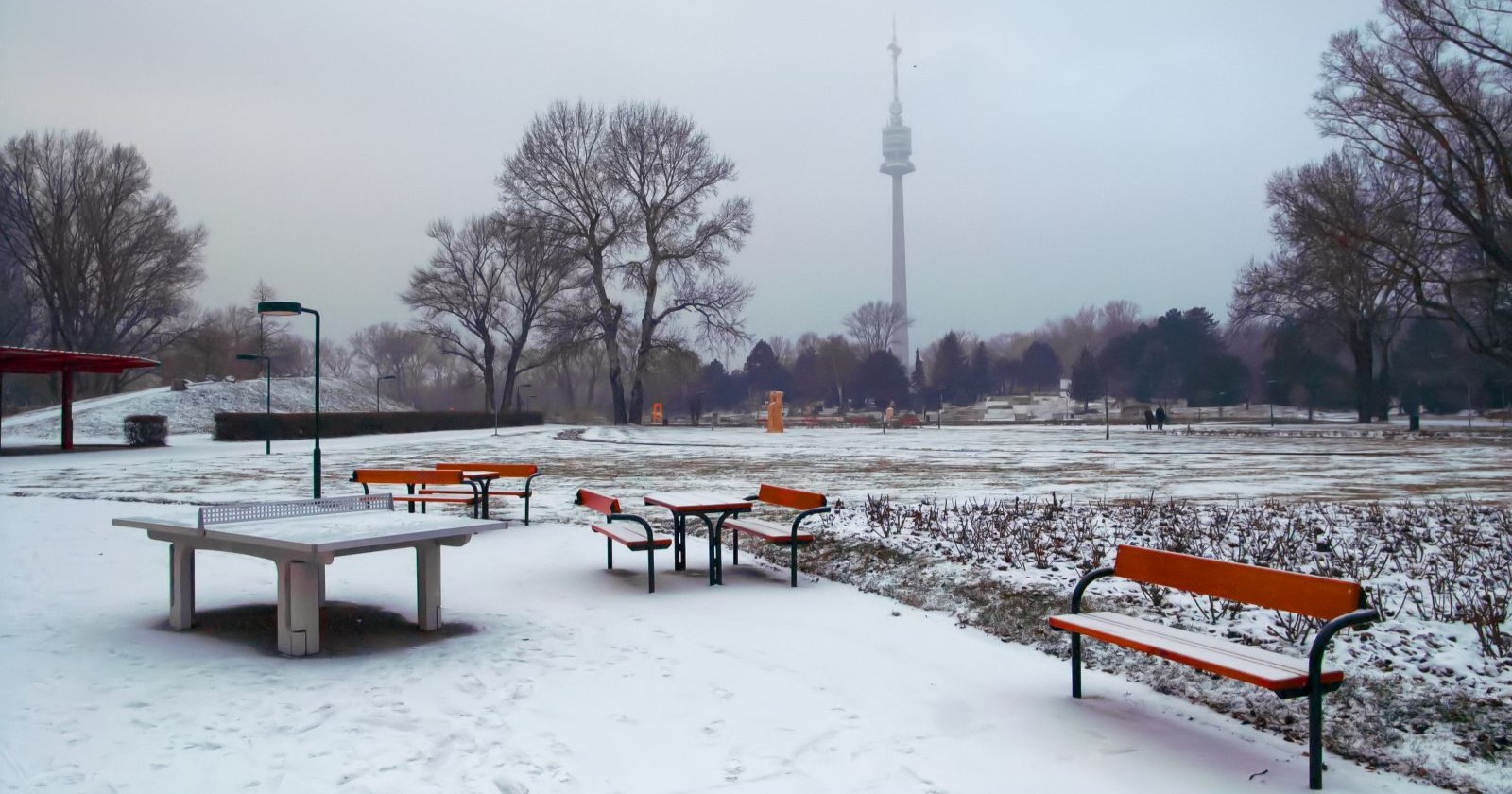 Das Wetter wird kalt: Verschneiter Donau-Park mit Blick auf den Donauturm, Symbolbild für das Wetter und den kommenden Frost und Schnee am Faschingsdienstag.