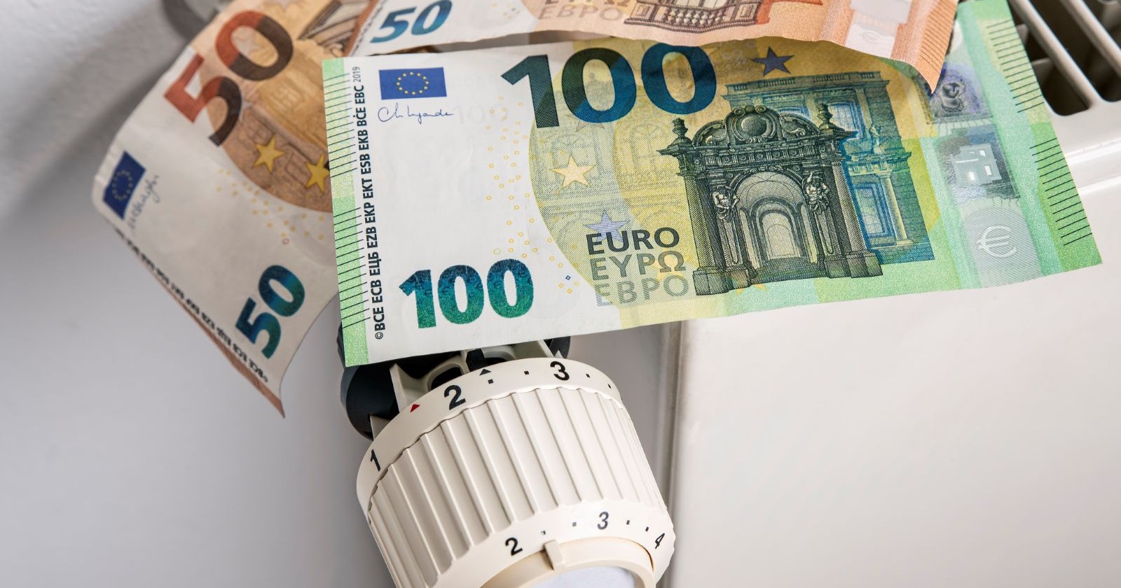 Mehrere Euro-Scheine liegen auf einem Heizkörper – Symbolbild für Heizkosten und Zuschuss in Oberösterreich 2026.