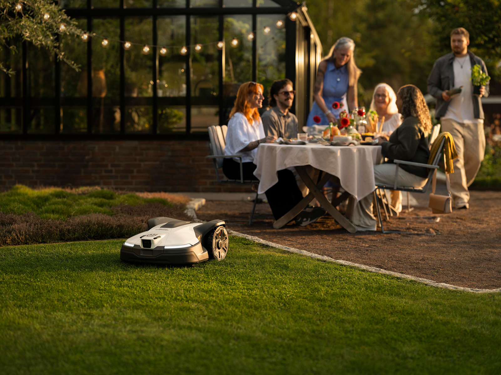 Glückliche Familie im Garten bei Sonnenuntergang | Credit: Husqvarna