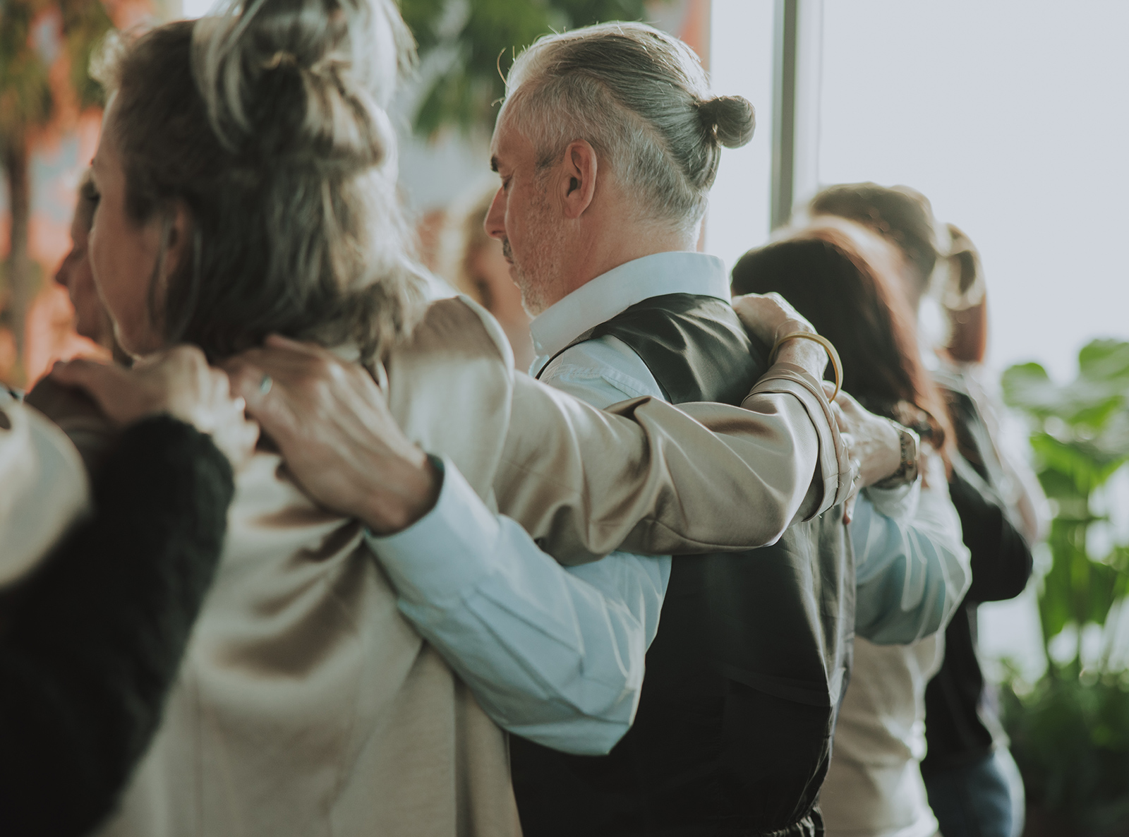 Teilnehmende einer Achtsamkeitsübung stehen Arm in Arm zusammen | Credit: Tassilo Edelsbacher