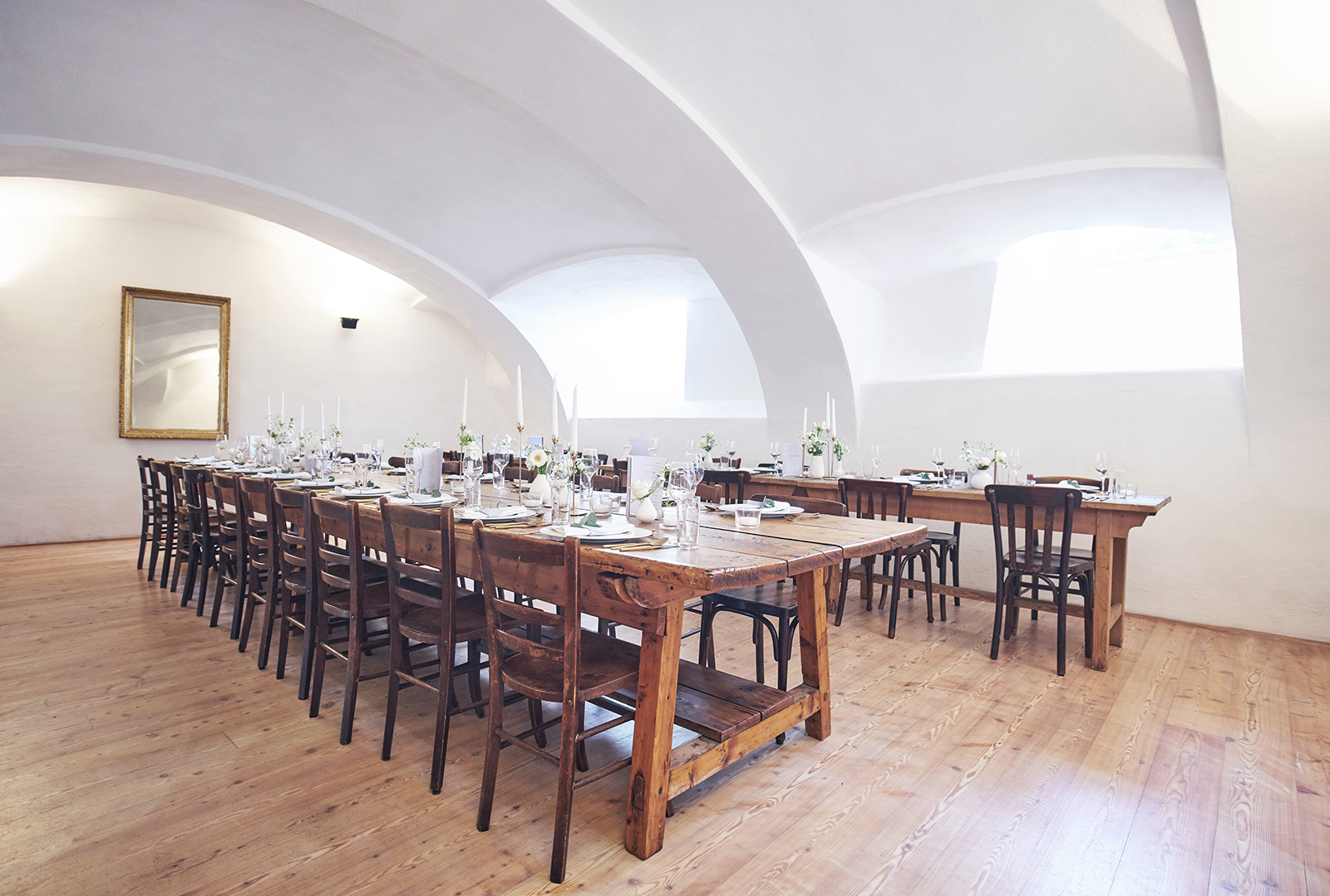 Langer Holztisch mit Stühlen in einem Gewölbe | Credit: Peter Burgstaller