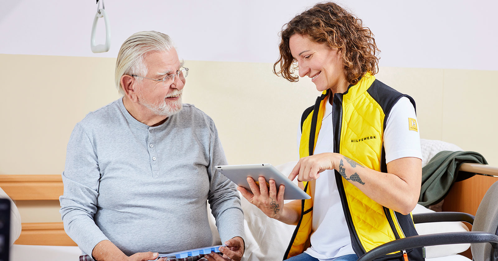 Pflegerin im Gespräch mit einem älteren Patienten | Credit: Hilfswerk/Johannes Puch