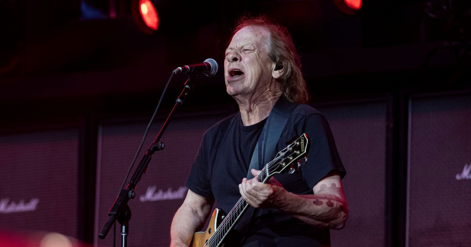 AC/DC-Gitarrist Stevie Young live auf der Bühne während der „Power Up“-Tour mit E-Gitarre und Mikrofon