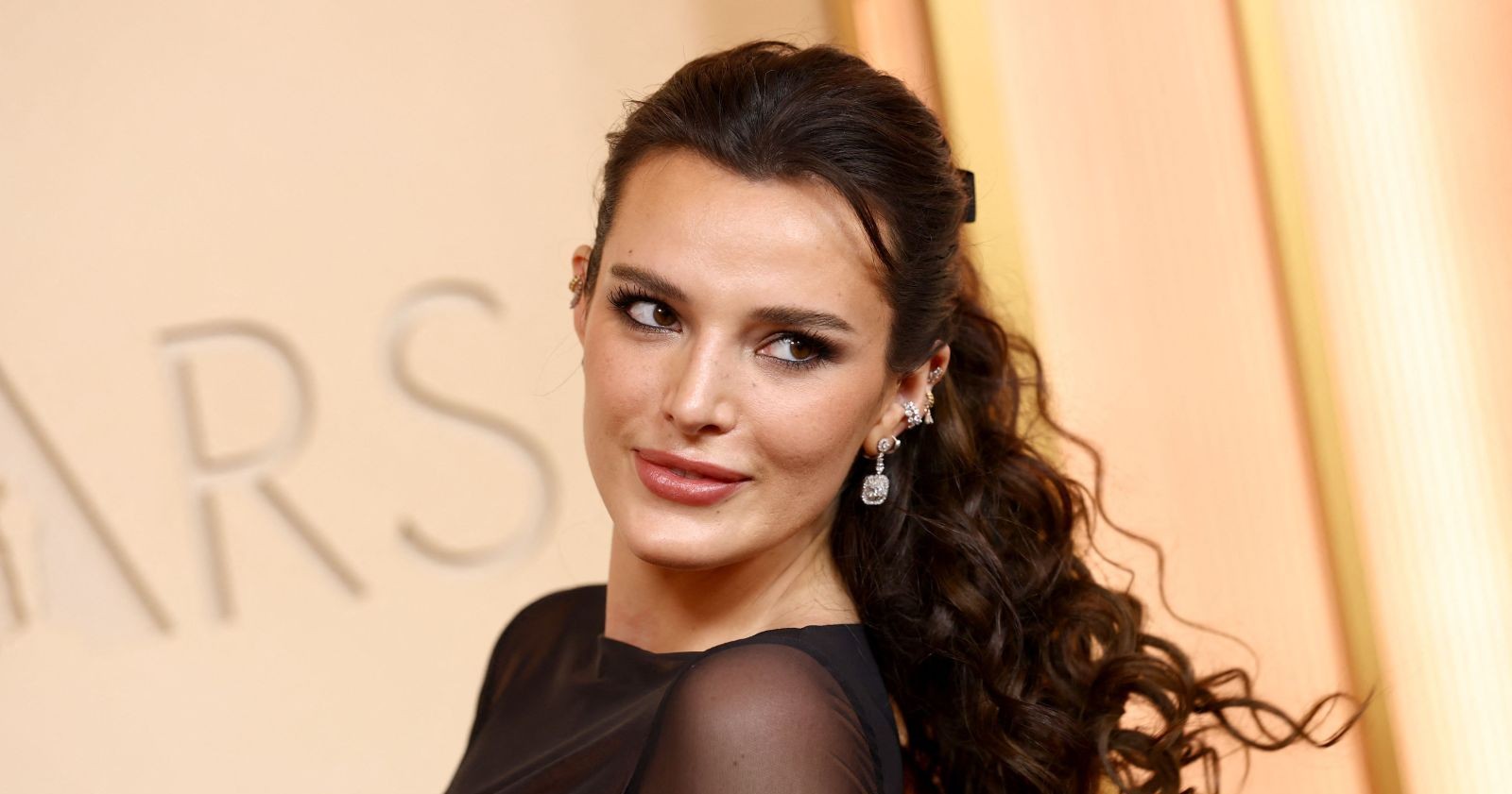 Bella Thorne bei den Oscars 2026 mit transparentem schwarzen Look und sichtbarem Piercing auf dem roten Teppich