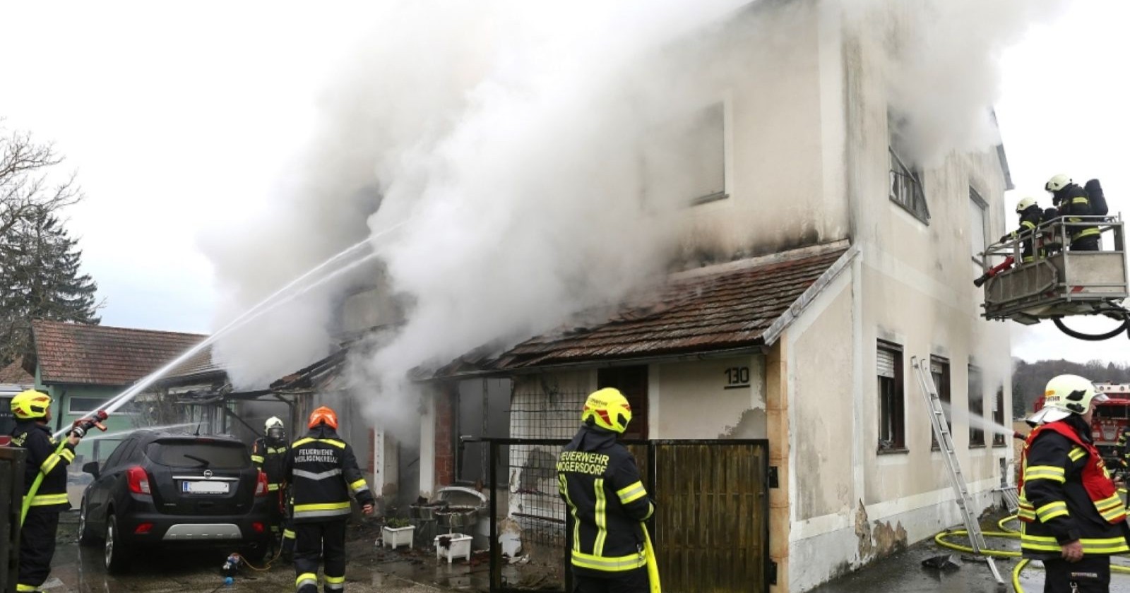 Einsatzkräfte der Feuerwehr löschen den schweren Brand an einem Haus in Mogersdorf