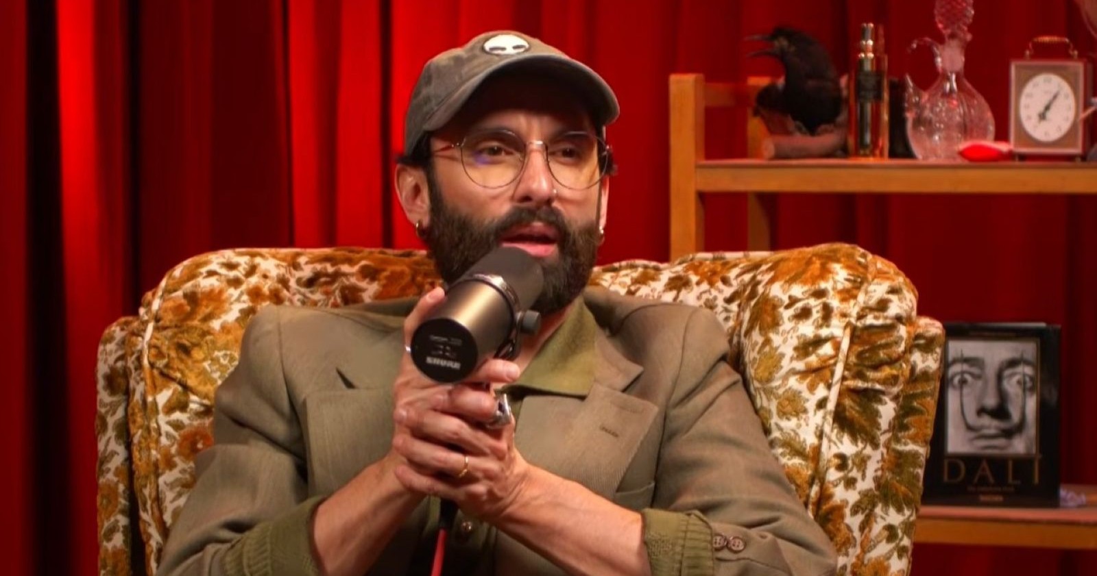 Conchita Wurst spricht im Podcast „Bussi Bla Bla“ mit Mikrofon über Schönheitsoperation und Beauty-Eingriffe