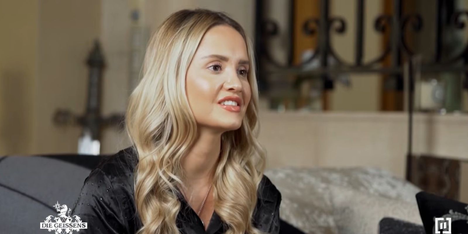 Davina Geiss sitzt in einer Szene aus „Die Geissens – Eine schrecklich glamouröse Familie“ auf einem Sofa und spricht über traditionelle Rollenbilder, was bei Fans und Schwester Shania Geiss für Kritik sorgt.