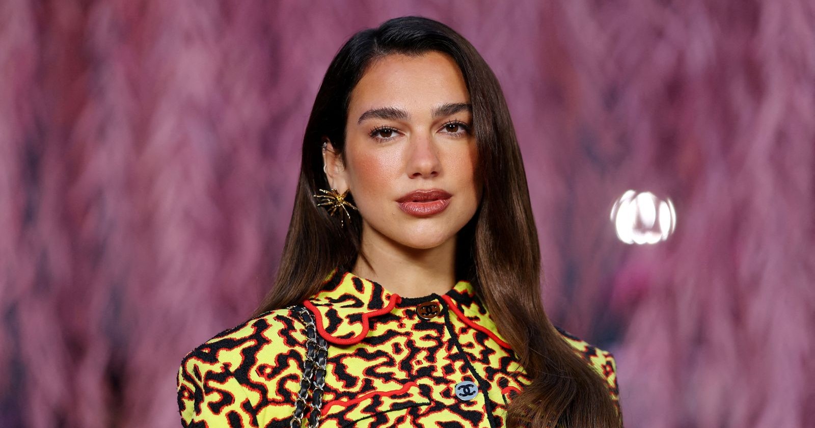Dua Lipa als Nespresso Markenbotschafterin im Close-up mit auffälligem Outfit vor pinkem Hintergrund