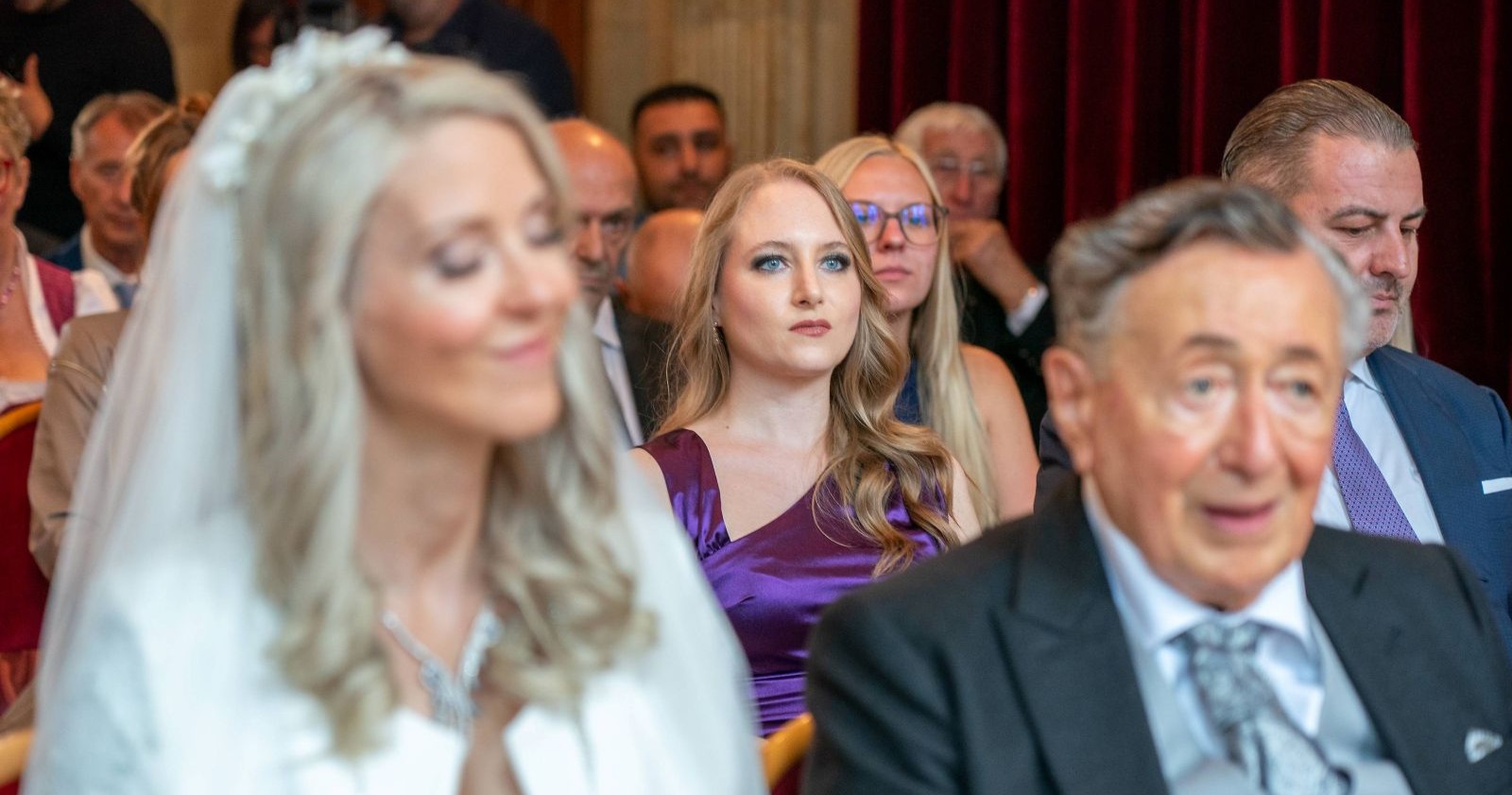 Jacqueline Lugner sitzt bei der Hochzeit von Simone Lugner und Richard Lugner im Publikum und blickt ernst nach vorne