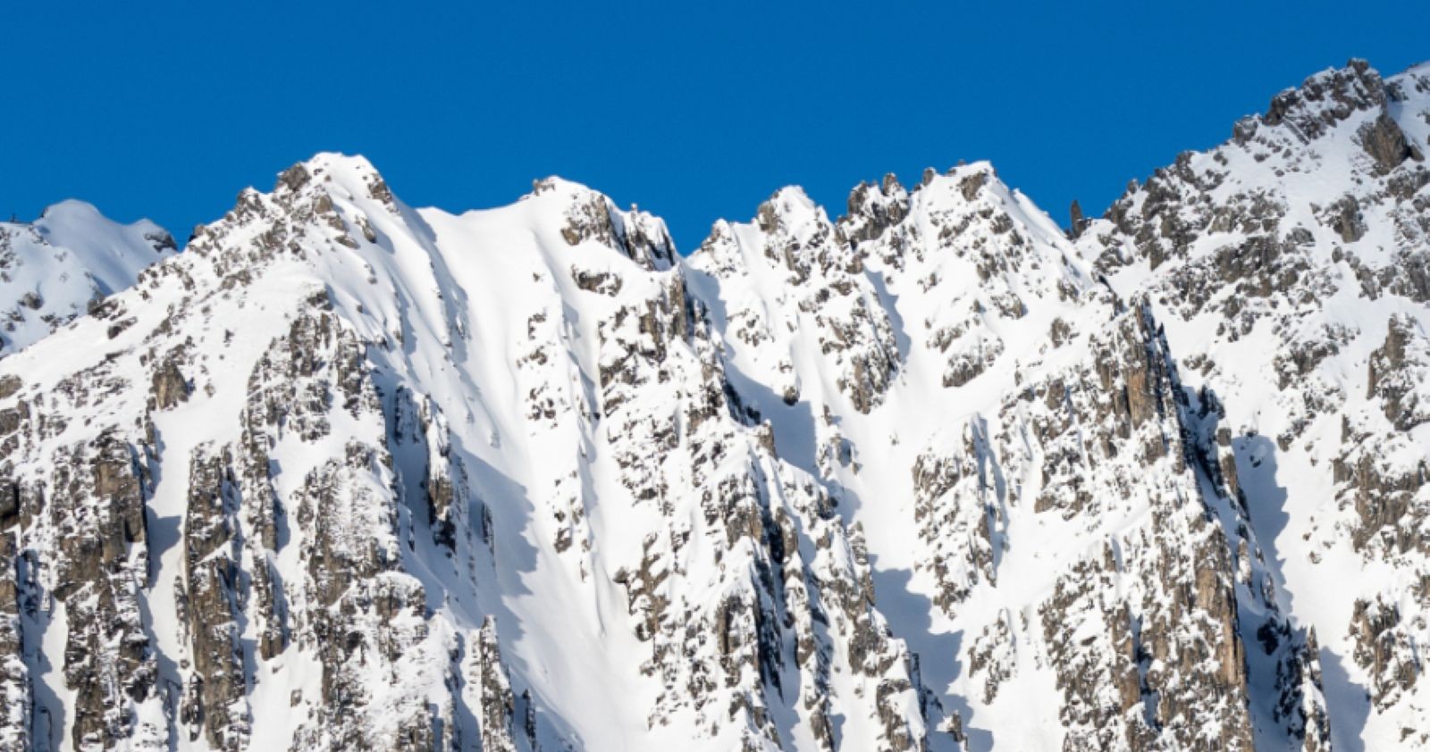 Steile, schneebedeckte Alpen in Tirol mit erhöhter Lawinengefahr, viel Neuschnee und potenziellen Lawinenhängen nach Wintereinbruch