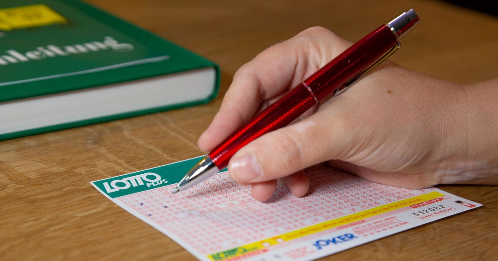 Lotto Ziehung heute: Hand die einen Lottoschein in einer Annahmestelle ausfüllt.