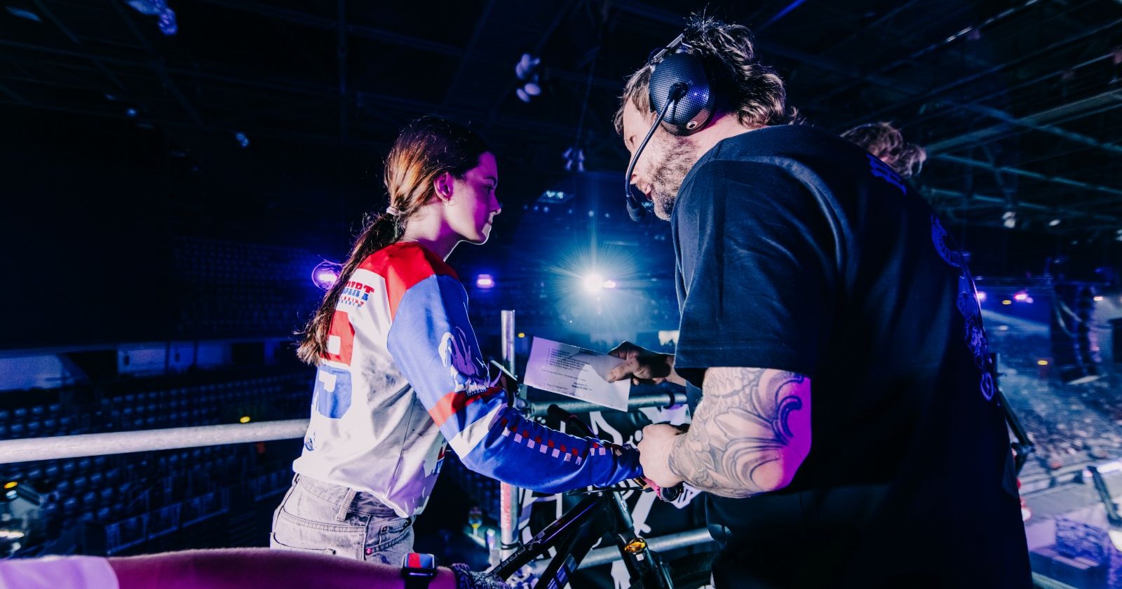 Junge Bikerin wird vor dem Stunt instruiert