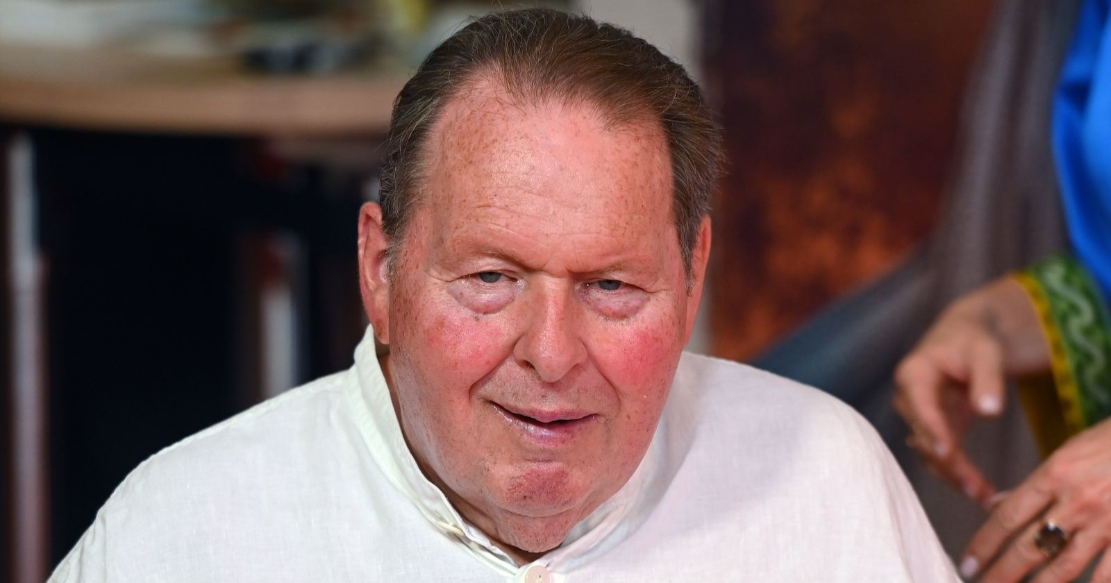 Ein Mann im weißen Hemd schaut in die Kamera