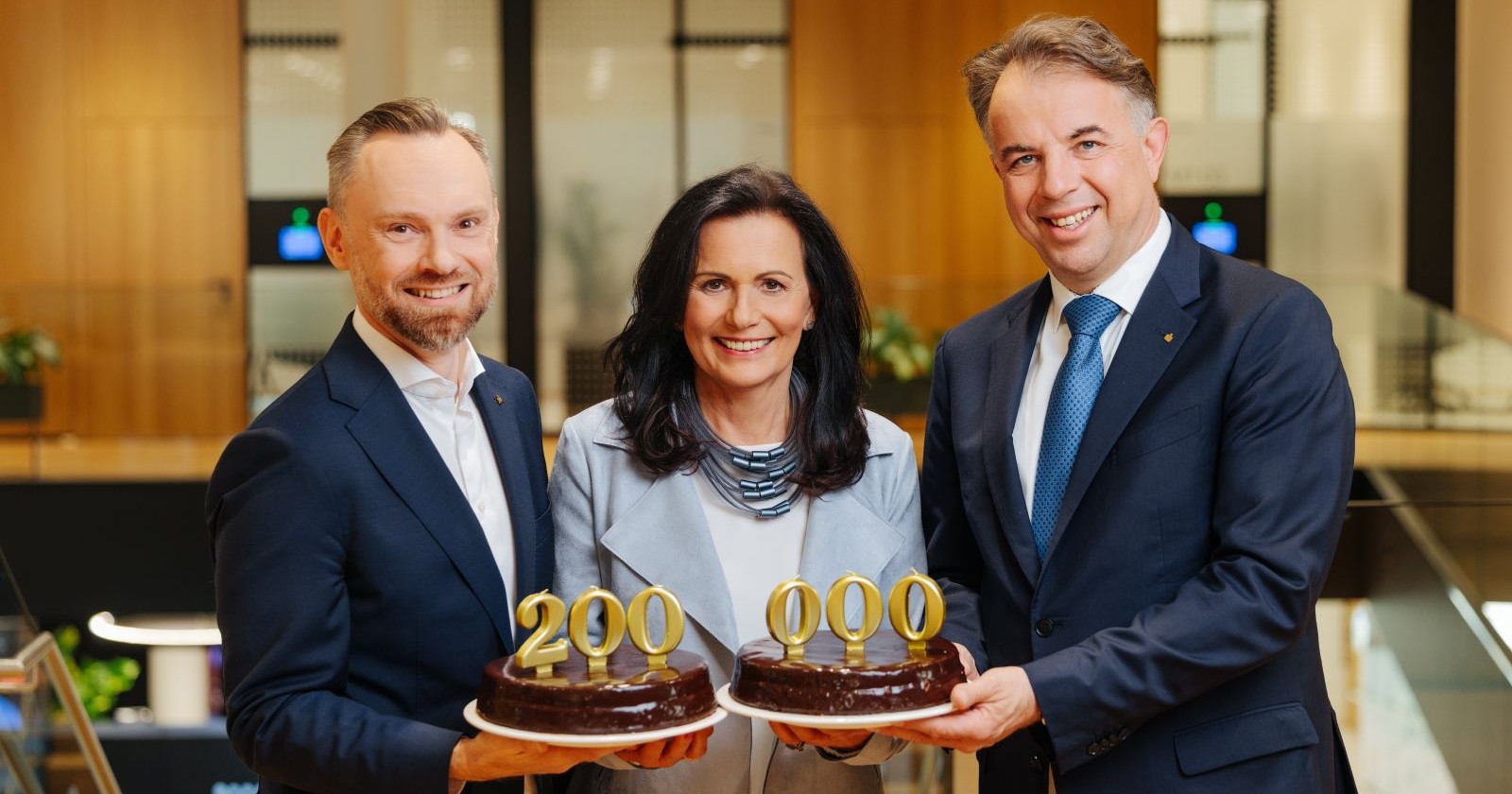 Kärntner Sparkasse Vorstand präsentiert 200.000 Kunden Meilenstein mit Torten in Klagenfurt Filiale