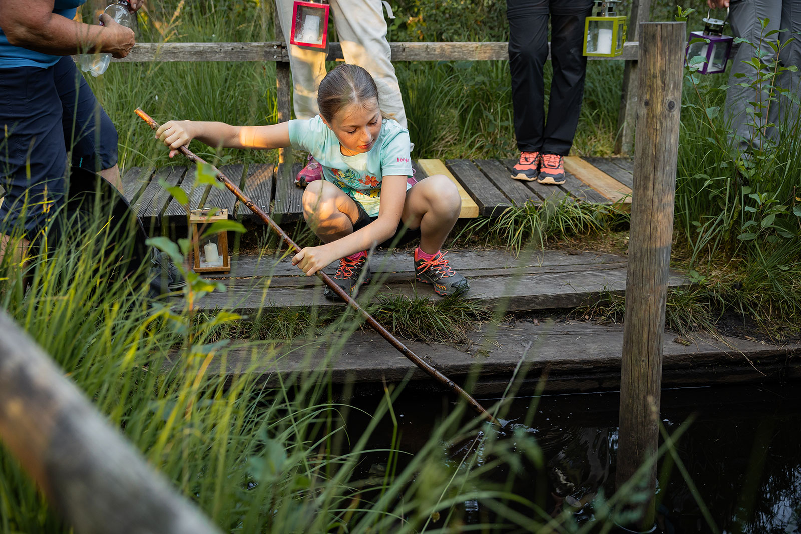 Mädchen fischt etwas aus dem Teich | Credit: Helena Wimmer