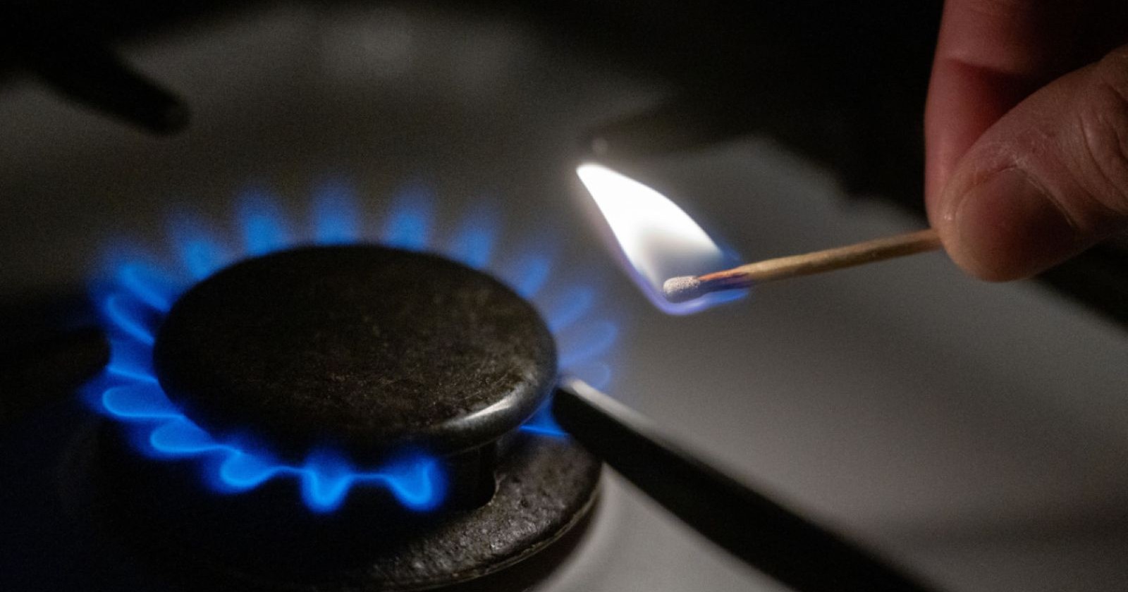 Gasflamme auf Herd wird mit Streichholz entzündet – steigende Gaspreise und Energiekrise in Europa