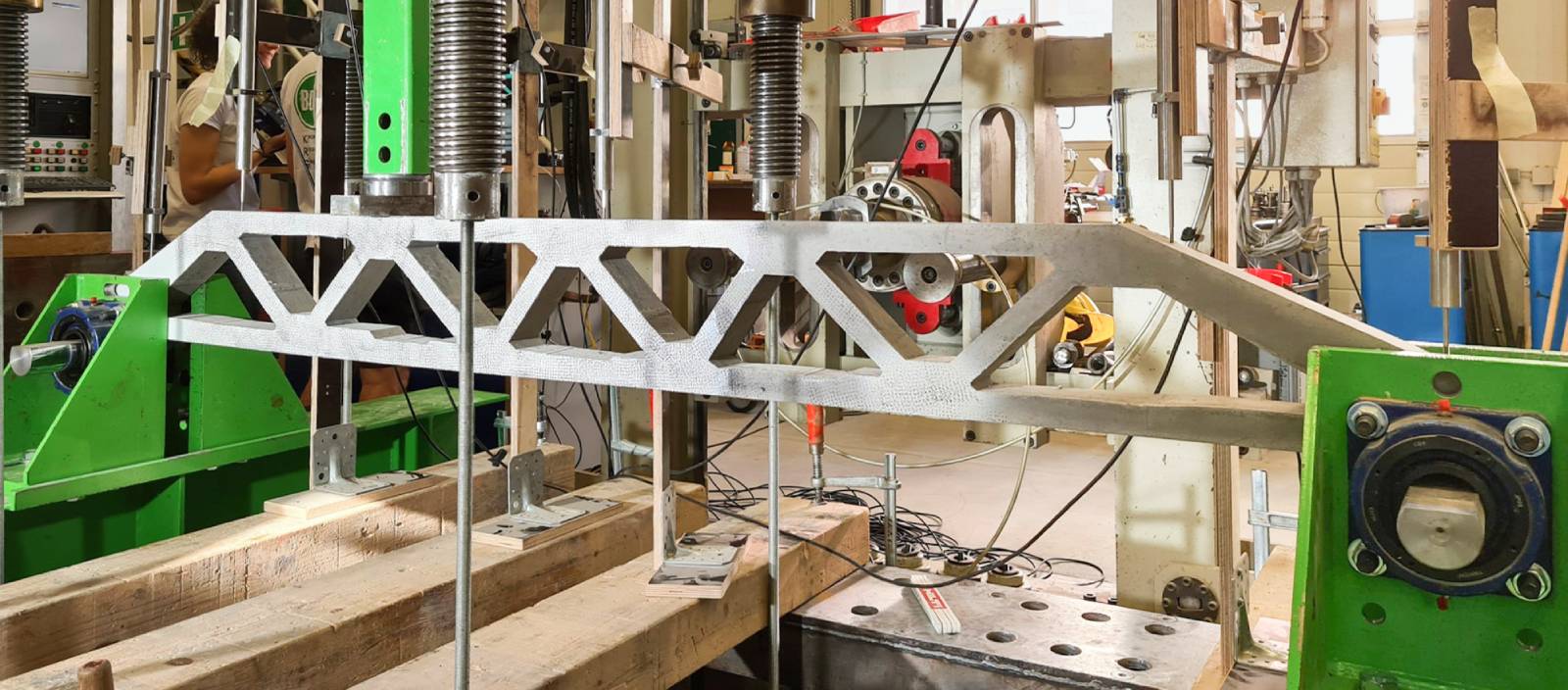 Industrielle Fertigung: Metallrahmen wird in einer Werkhalle von Maschinen bearbeitet und montiert