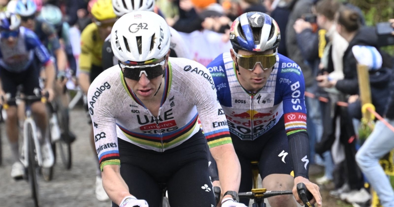 Tadej Pogacar und Remco Evenepoel fahren dicht nebeneinander bei einem Radrennen auf Kopfsteinpflaster.