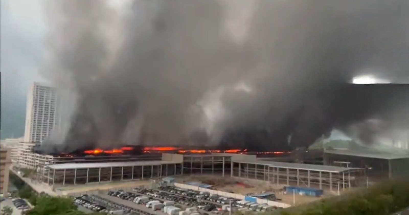 Großbrand iBYD Brand Parkhaus in Shenzhen mit meterhohen Flammen und schwarzer Rauchentwicklung über einem Parkhauskomplex