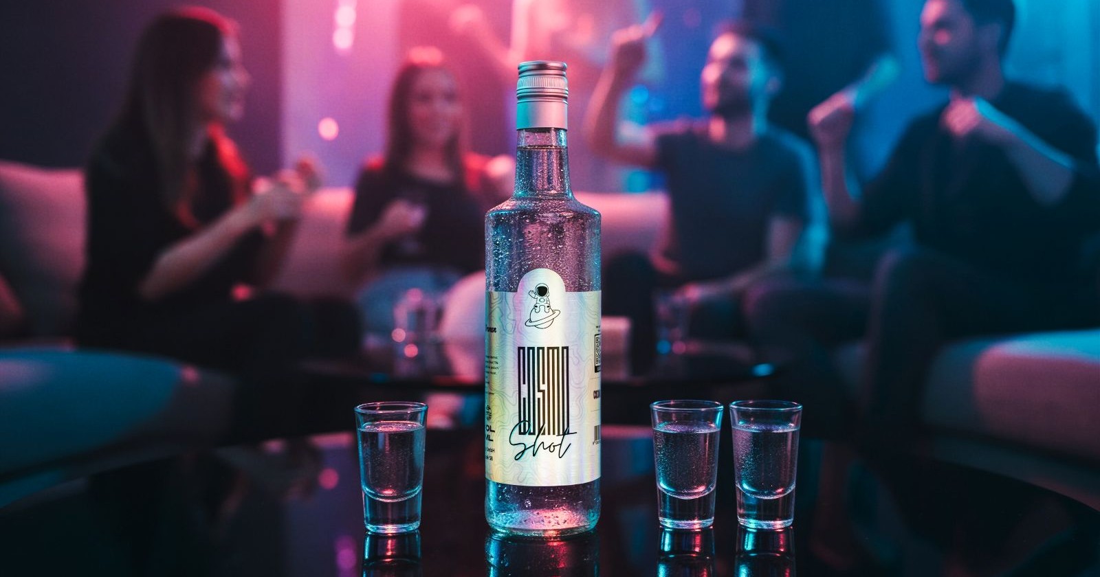 Eine Flasche und zwei Gläser auf einem Tisch in einem Club mit jungen Menschen