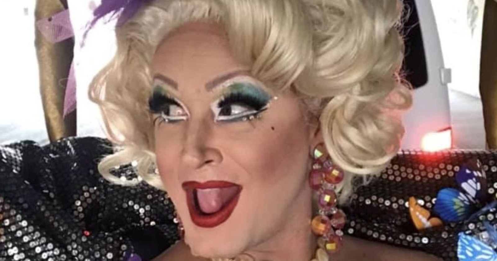 Gigi La Pajette, Dragqueen aus Salzburg, mit blondem Styling, auffälligem Make-up und glitzerndem Bühnenoutfit