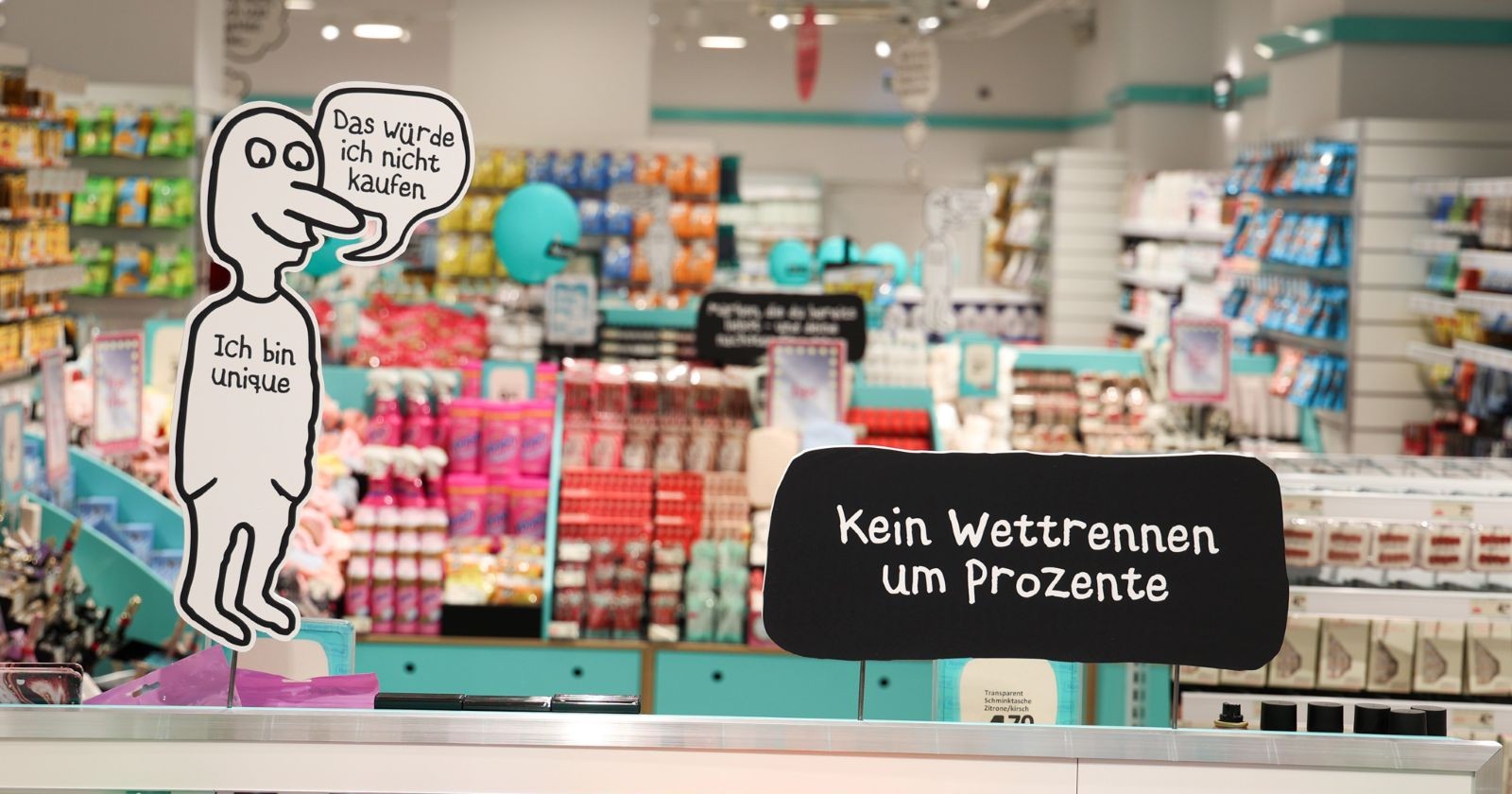Innenansicht eines Normal Stores in Wien mit bunten Regalen, Beauty-Produkten und Hinweisen zum Fixpreis-Konzept ohne Rabattaktionen