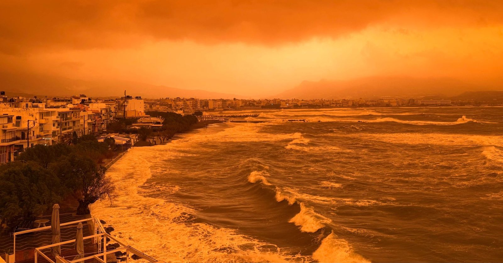 Saharastaub über Kreta färbt Himmel orange, starke Wellen an Küste, schlechte Sicht durch Feinstaubbelastung im Mittelmeerraum.