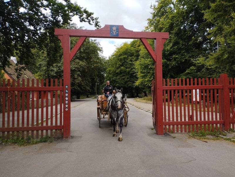 The red monogrammed gate at Klampenborg, with a pony trap coming through it