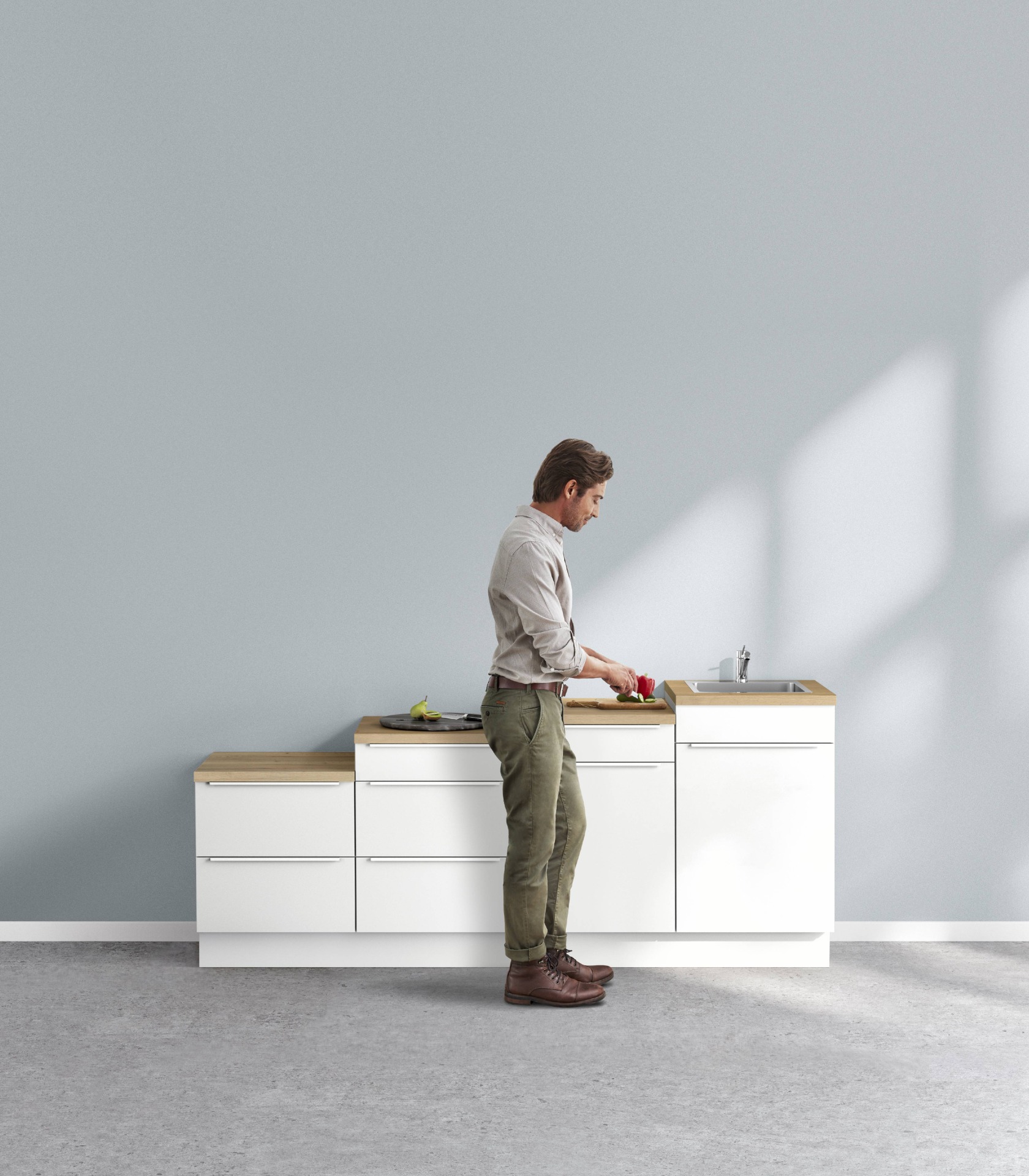 Mann arbeitet an einer Küchenzeile, Arbeitshöhe im Blick