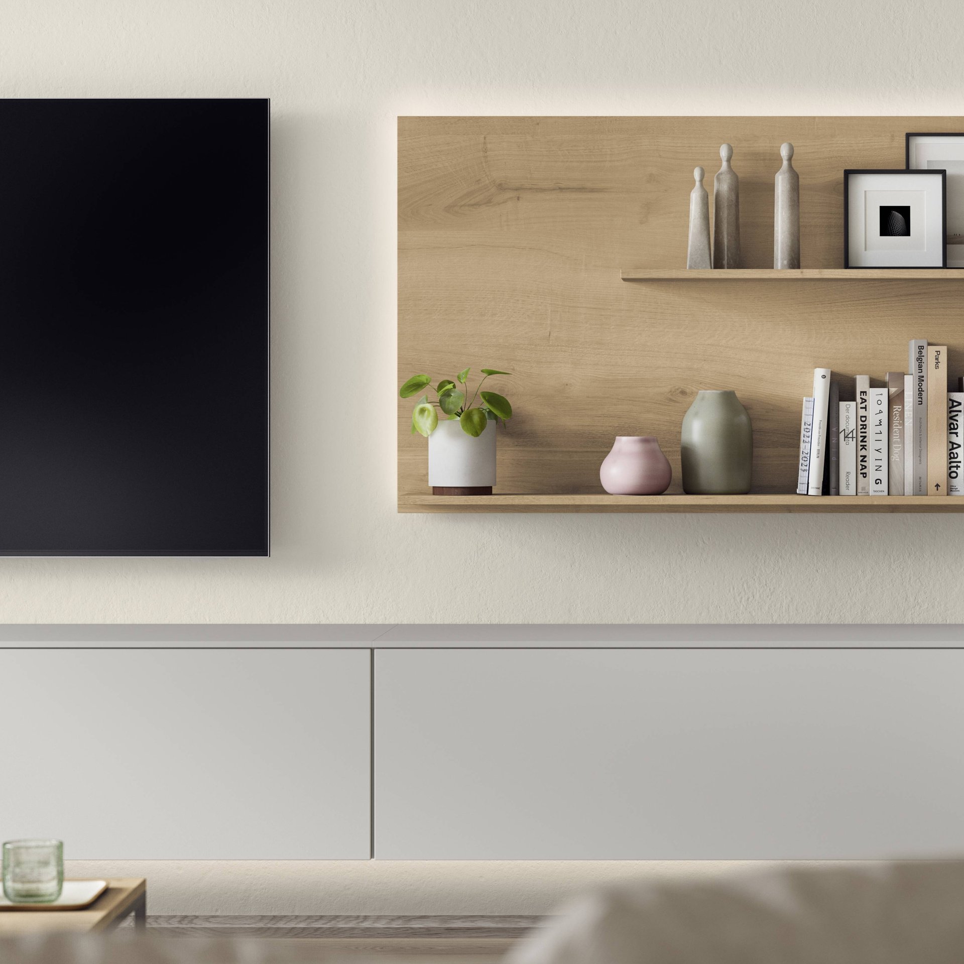 Hellgraues hängendes Lowboard ohne Griffe unter einem Fernseher, daneben eine Wandplatte in Holzoptik mit Büchern und Vasen, Nobilia Softline