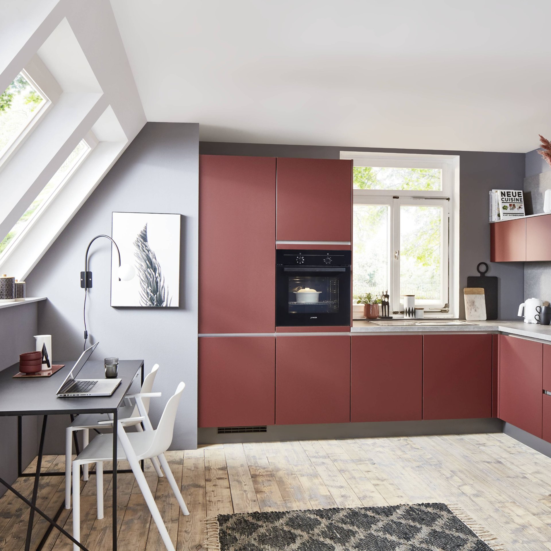 Rote grifflose L-Küche mit Hochschränken und Einbaubackofen neben dem Fenster, darunter Unterschränke mit Griffmulde, Nobilia Line N Easytouch
